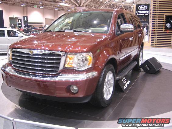 Red Chrysler Aspen SUV on display. A sign says 'ASPEN'