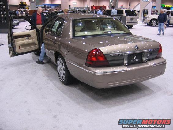 Tan Mercury Grand Marquis with driver's door open, rear view