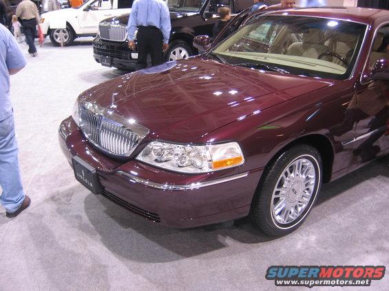 Maroon Lincoln Town Car front quarter view with chrome grille and headlights