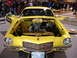 1981 Ford Mustang - A bright yellow Chevrolet Camaro is displayed with its hood open, revealing the engine and a "Camaro" decal on the fender.