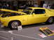 1981 Ford Mustang - A yellow coupe is displayed with its hood open, revealing the engine and chrome wheels.