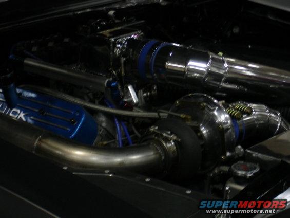 Engine bay with turbocharger and blue valve cover with 'QUICK' text