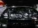 1981 Ford Mustang - Engine bay of a black car, polished chrome parts and engine components.