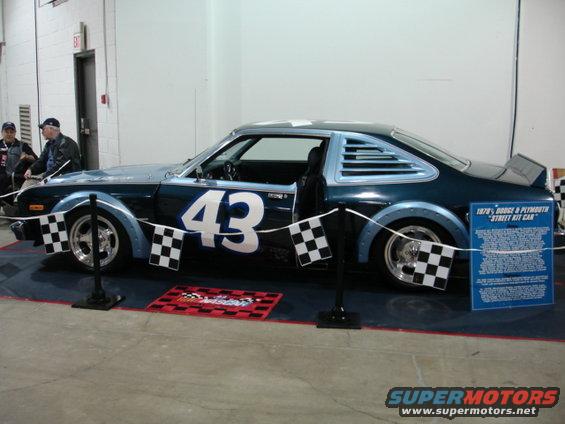 Side view of a dark blue 1978 Dodge & Plymouth "Street Kit Car" with number 43 on the door and checkered flags