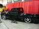 1981 Ford Mustang - A custom black pickup truck is displayed indoors with a yellow truck in the background.
