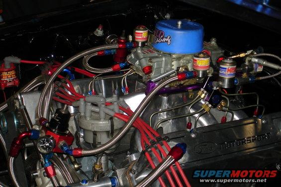 Engine bay with chrome manifold, blue air filter, and red spark plug wires