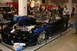 1981 Ford Mustang - A custom black drag car with striking blue flame graphics and a powerful exposed engine is displayed indoors.