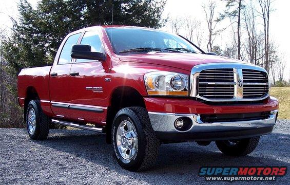 Red 2006 Dodge 2500 Quad Cab 4x4 pickup truck parked on gravel
