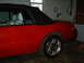 1986 Ford Mustang - Side view of a red 1986 Ford Mustang convertible with its black top up.