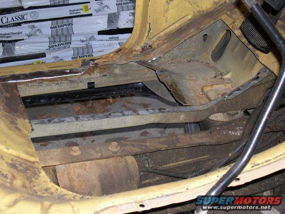 rusted out frame and floor pan of a vehicle, showing structural damage