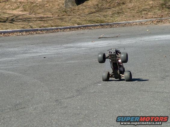 Remote control monster truck on its side on asphalt road