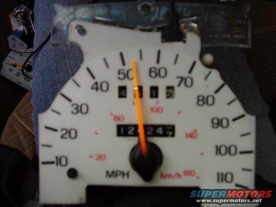 Car speedometer gauge with orange needle pointing to 50 MPH, odometer reads 12247
