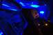 1985 Ford Crown Victoria LTD - The interior of a car trunk is illuminated by blue LED lights, highlighting audio equipment and speakers.