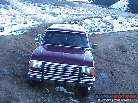 1988 Ford Bronco front view on dirt road with snow in background