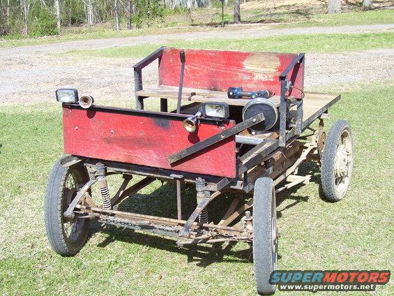 Custom-built red vehicle with wooden seating and wire wheels