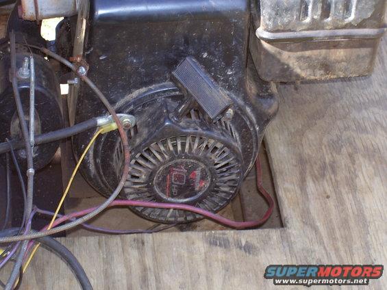Close-up of a small engine's pull starter and wiring. Text on the starter reads '10 HP'