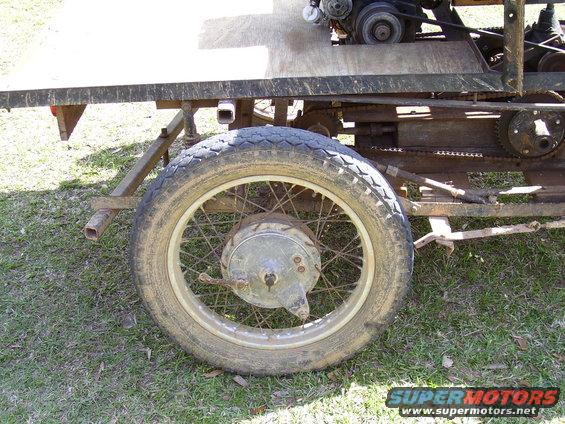 Close-up of a spoked wheel and drivetrain on a custom vehicle