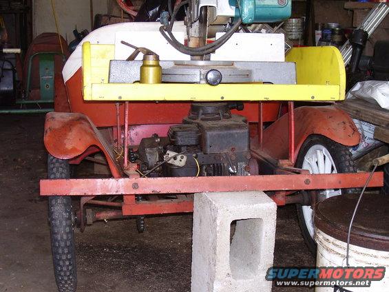 Custom motorized cart with red fenders, yellow trim, and a visible engine