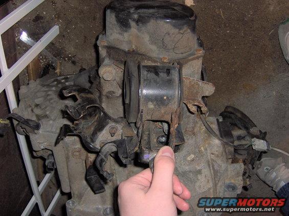 Engine and transmission assembly with a hand pointing to a mount