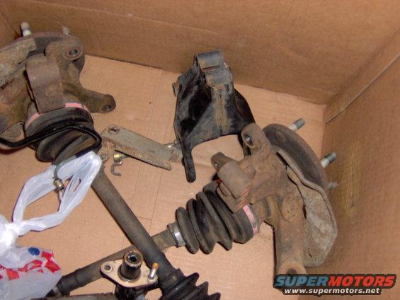 Box of used front suspension components, including CV axles and steering knuckles