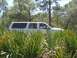 2000 Ford Excursion - A white 2000 Ford Excursion is seen driving through dense foliage, with several passengers visible inside.