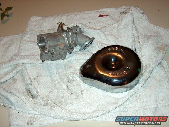 Motorcycle carburetor and chrome air cleaner cover with 'S&S SUPER' text, resting on a stained white towel