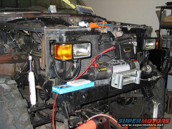 1981 Ford Bronco front end with winch installed, showing aftermarket headlights and shock absorber