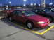 1995 Ford Thunderbird - Red coupe with a yellow '91 sticker on the windshield, parked in a lot at dusk.