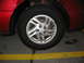 1995 Ford Thunderbird - Close-up of a red car's wheel and fender, showing a silver five-spoke rim.