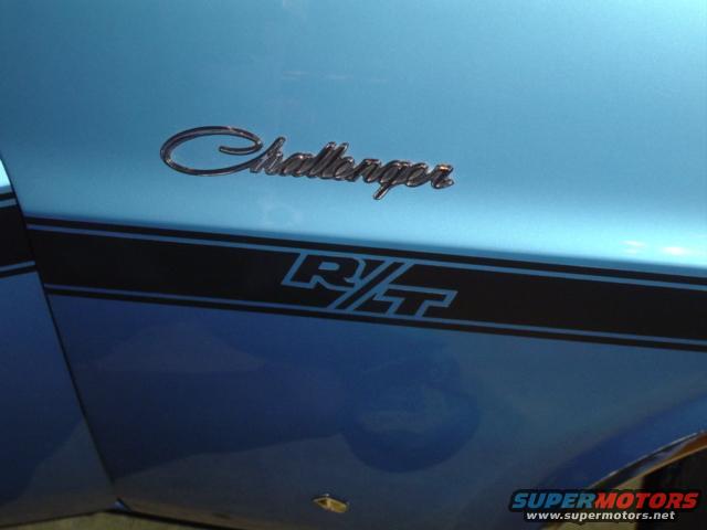 Side view of a blue car with a black stripe and 'Challenger R/T' badging