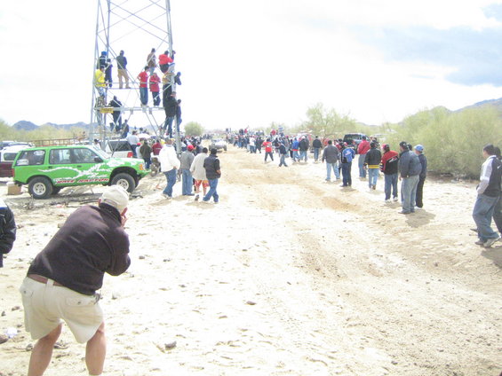 Green SUV with racing decals, parked on dirt, side view