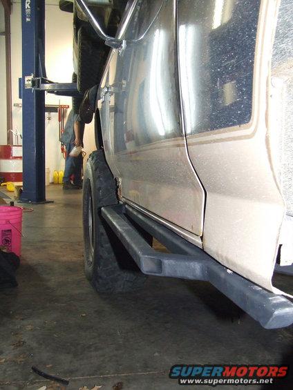 Close-up of aftermarket rock sliders installed on the side of a vehicle