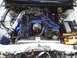 1996 Ford Thunderbird - The engine bay of a 1996 Ford Thunderbird, blue hoses and an aftermarket air intake system.