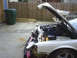 1996 Ford Thunderbird - The engine bay of a car is visible with the hood open, revealing the engine and various components.