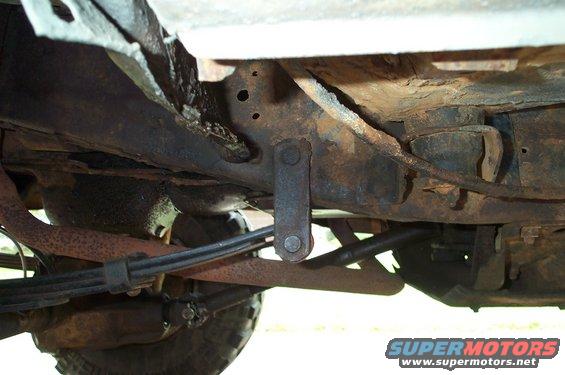 Undercarriage view of rusty suspension components and frame