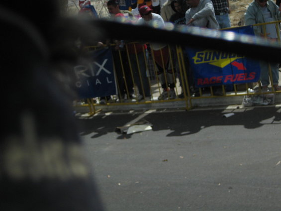 Crowd behind yellow barrier with banners reading 'RIX CIAL' and 'SUNDCO RACE FUELS'