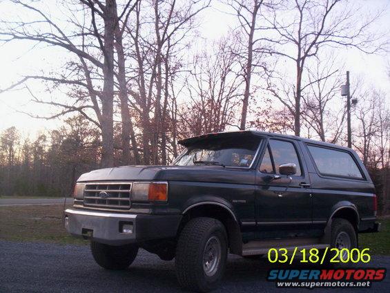 Dark green Ford Bronco parked outside with trees in the background. Date stamp shows 03/18/2006