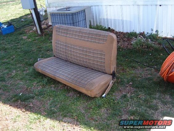 tan and brown plaid bench seat sitting on grass