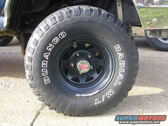 Close-up of a black wheel with a "DURANGO RADIAL M/T" tire. Red center cap visible