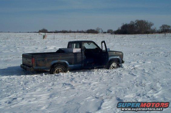 Pickup truck stuck in deep snow, driver's door open
