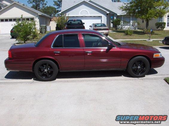 Red 2004 Ford Crown Victoria sedan, side view