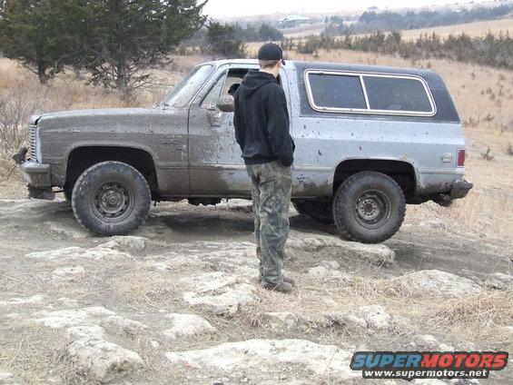 Mud-covered SUV, side view, light blue and silver