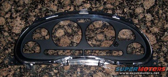 Black instrument cluster bezel with multiple circular and rectangular openings, chrome trim accents, and a "SUPER MOTORS" watermark