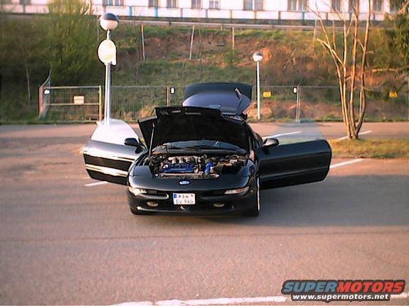 Black 1994 Ford Probe with hood and driver's door open, parked on asphalt