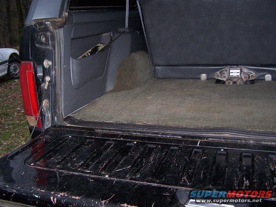 1992 Ford Bronco tailgate and cargo area, with another vehicle visible to the left