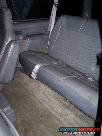 Back seat and floor of a vehicle. Seatbelts are visible