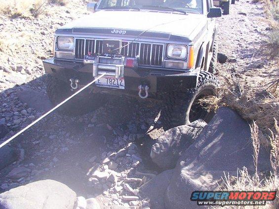 Jeep Cherokee XJ with winch on rocky trail, another vehicle behind