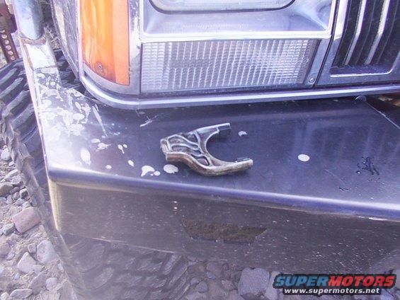Black front bumper with white paint splatters and a broken metal piece on top