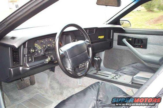 1990 Chevrolet Camaro interior showing dashboard, steering wheel, gear shifter, and seats