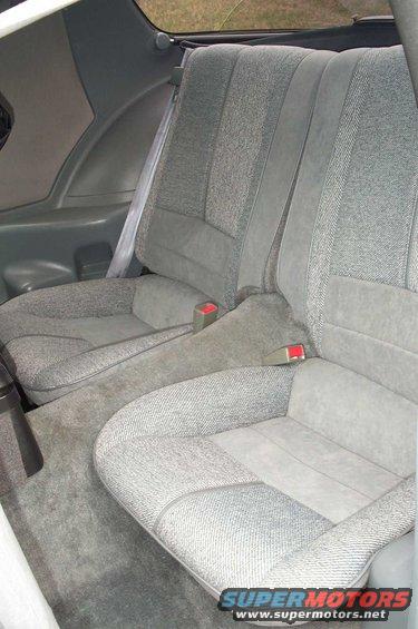 Gray fabric rear seats with gray carpet and red seatbelt buckles